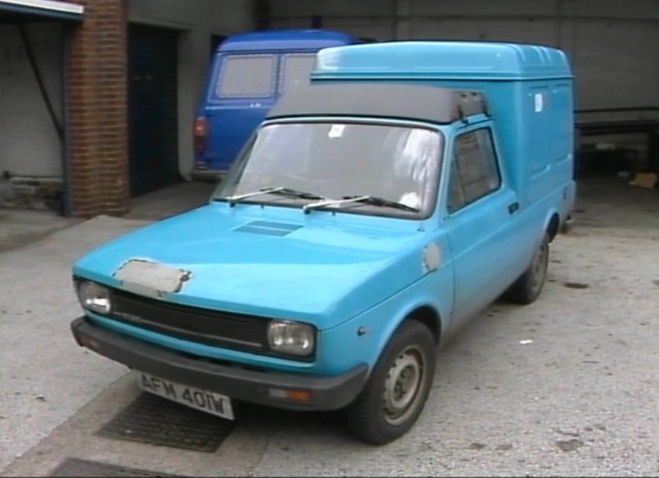 Van de fiat de azul claro estacionado en un garaje.