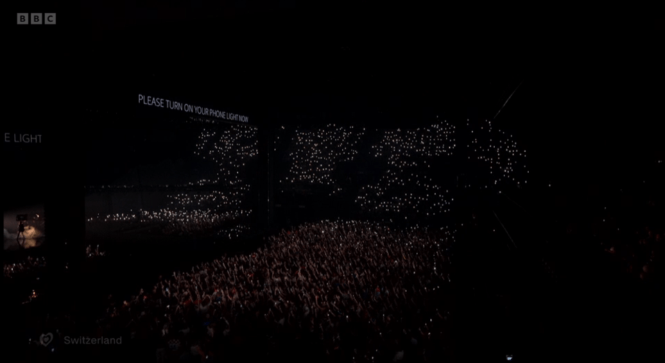 Audiencia de concierto con teléfonos iluminados.