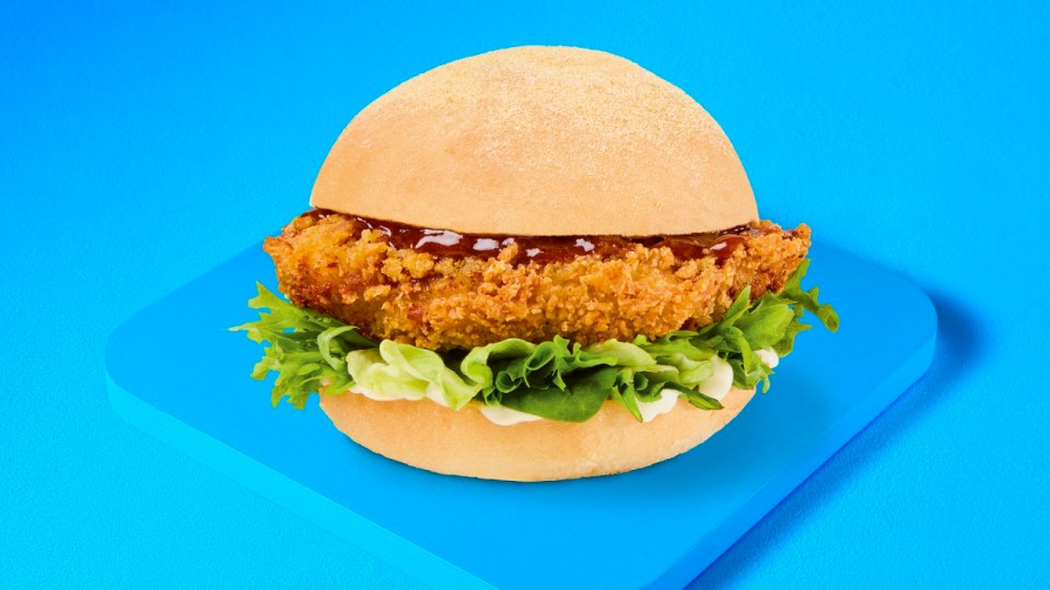 Hamburguesa de pollo crujiente con lechuga y salsa.