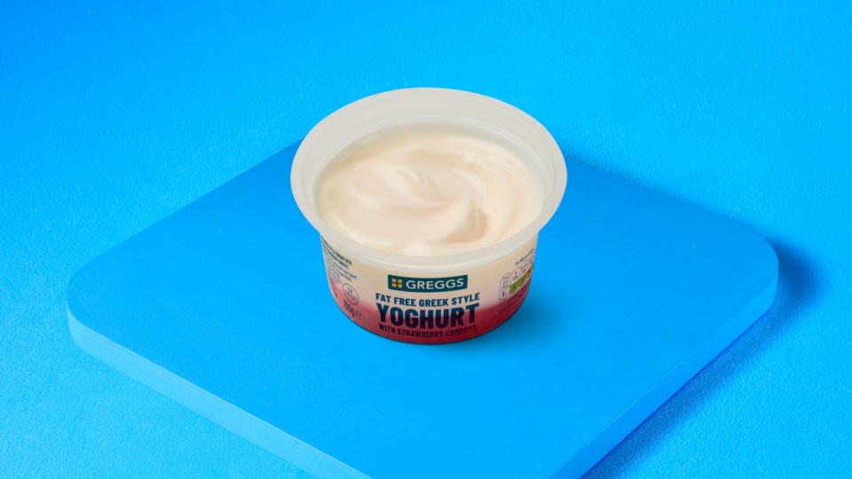 Una taza de yogurt griego sin grasa de Gregg's con compota de fresa.