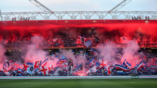 © IMelo - The Fankurve Sampdorias en el estadio Marassi en el penúltimo partido de partido de la Serie B 2024/25 © IMelo - La imagen muestra la curva de admiradores completos del club de fútbol italiano Sampdoria Genoa en un estadio. La vista va desde el centro del campo directamente hasta las gradas detrás de la puerta. La tribuna está densamente llena de fanáticos, que giran numerosas banderas grandes y pequeñas en los colores del club azul, blanco, rojo y negro. Muchas banderas muestran logotipos, letras o imágenes de jugadores famosos. Los bengalos rojos y las antorchas de humo brillan en el área superior de las gradas, lo que sumerge la escena en una intensa luz roja. En el área inferior, se puede ver humo grueso en tonos rosados y rojos que se extienden sobre los fanáticos. La atmósfera se ve muy fuerte, enérgica y emocionalmente, típica de un "Ultras"-Curve de Fank en un juego importante. El campo vacío se puede ver en primer plano, con un gol en el medio. En la parte inferior de la derecha hay un marcador electrónico que el tiempo "00:00" espectáculos. También se puede ver la construcción del estadio con techo e iluminación. La escena de la imagen transmite una fuerte pasión y apoyo de los fanáticos para su equipo.