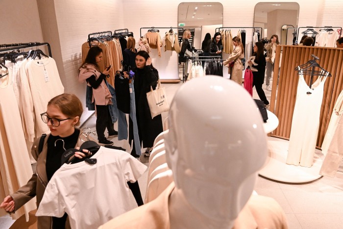 Los compradores navegan por los estantes de ropa dentro de la tienda Maag recientemente renombrada, anteriormente Zara, en Moscú