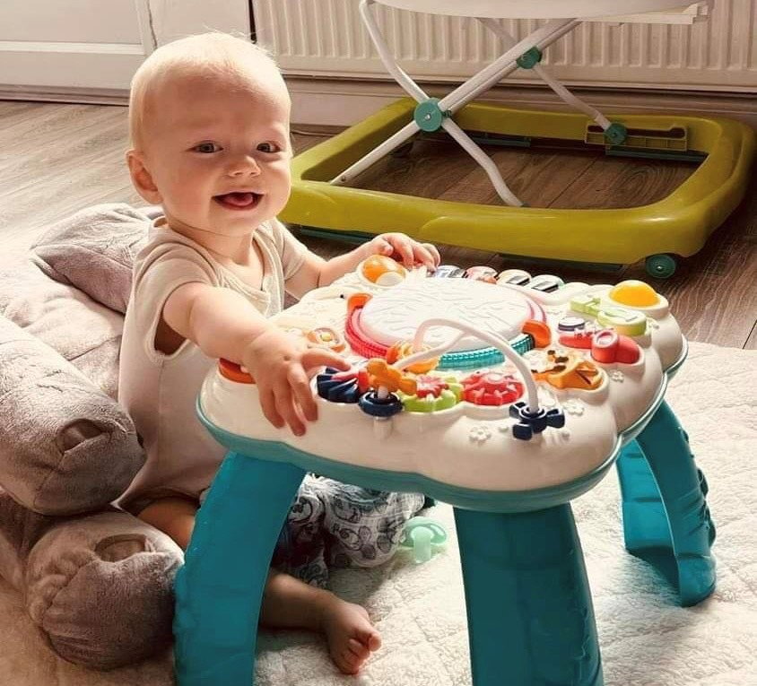 Bebé jugando con la mesa de actividades.