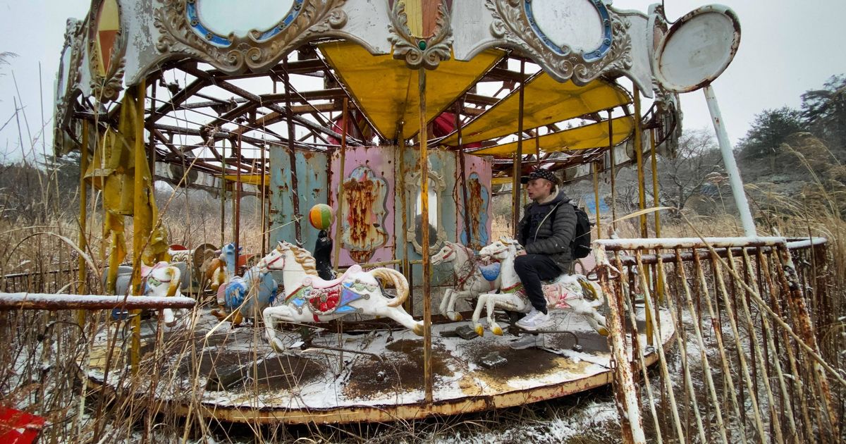 Parque temático abandonado con una arcade desmoronada y espeluznantes muñecos
