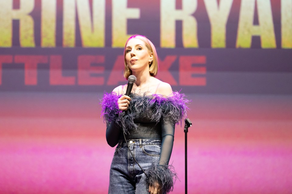 Katherine Ryan actuando en el escenario con un micrófono.