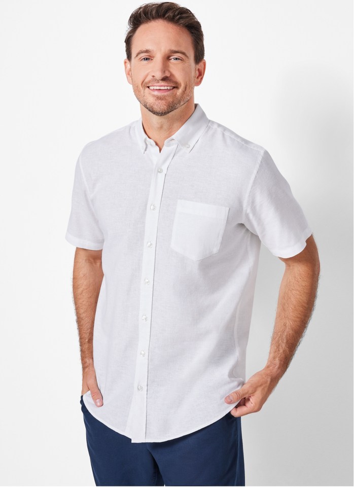 Hombre sonriendo y vistiendo una camisa de lino blanca.