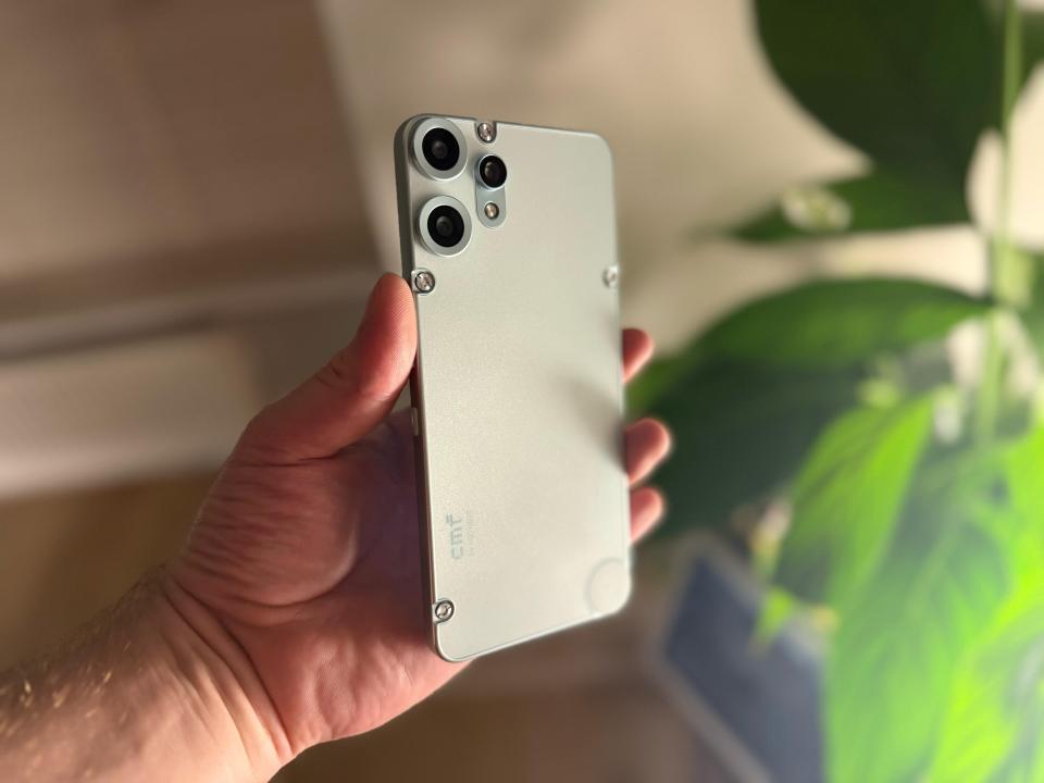 Persona que sostiene un teléfono inteligente de color gris claro.