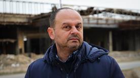 Samir Kazma se para frente a un edificio destruido.