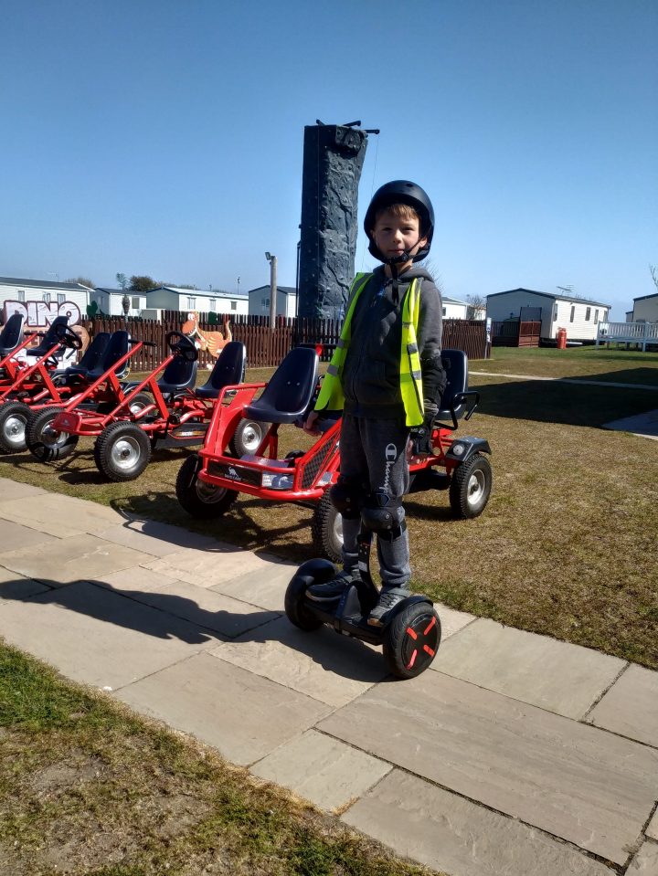 Chico en Hoverboard cerca de Go-Karts.