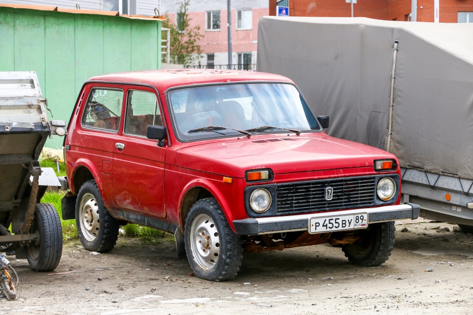 Red Lada Niva 4x4 estacionado en una calle de la ciudad.