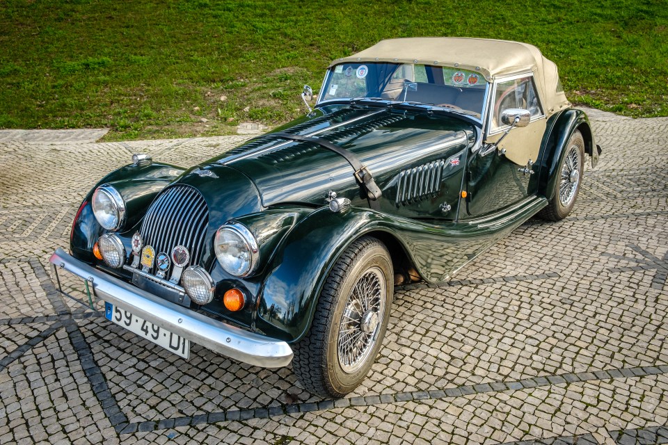 Dark Green Morgan 4-4 Sports Car estacionado en adoquines.