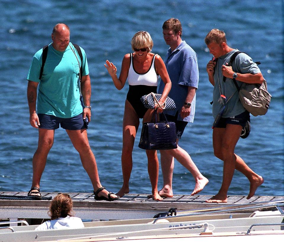 La princesa Diana y tres hombres caminando en un muelle en Saint-Tropez.