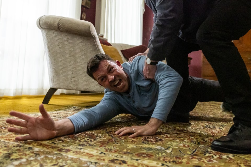 Un hombre está siendo restringido en el piso.