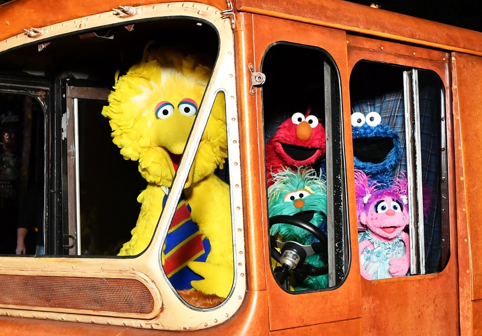 Big Bird, Elmo, Cookie Monster y Abby Cadabby en un vehículo antiguo.