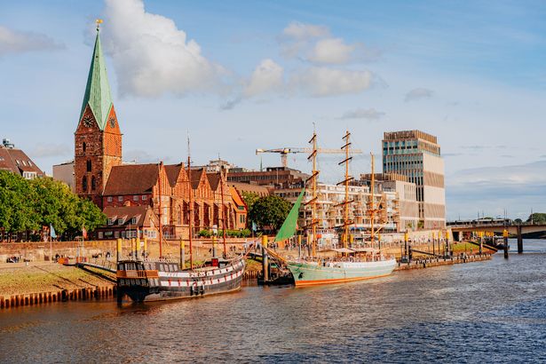 Cielos despejados, orilla del río, barcos y edificios históricos