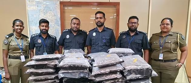 Oficiales de policía de pie con drogas confiscadas.