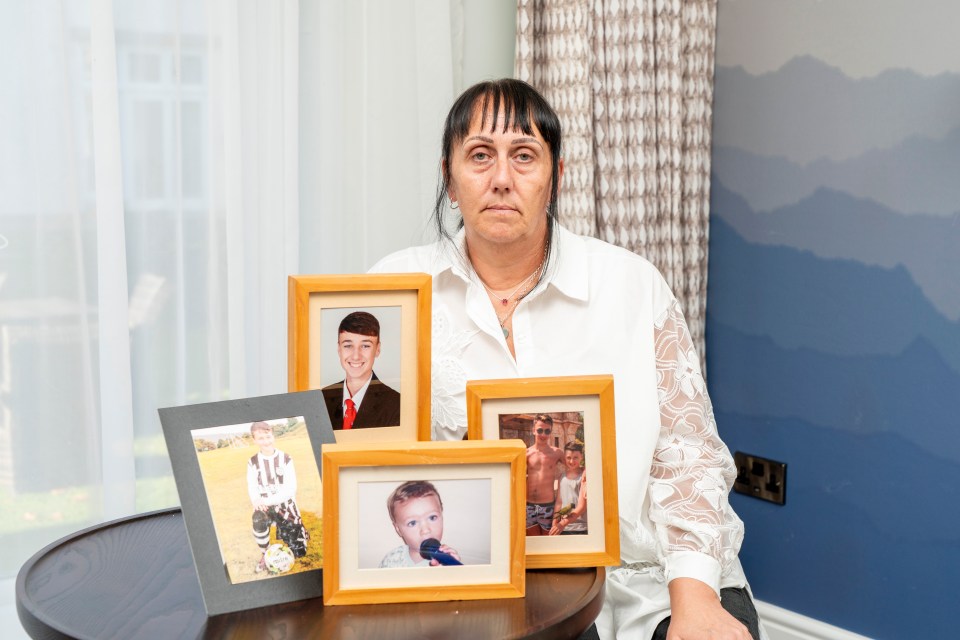Una mujer se sienta con fotos enmarcadas de su hijo fallecido y su hermano.