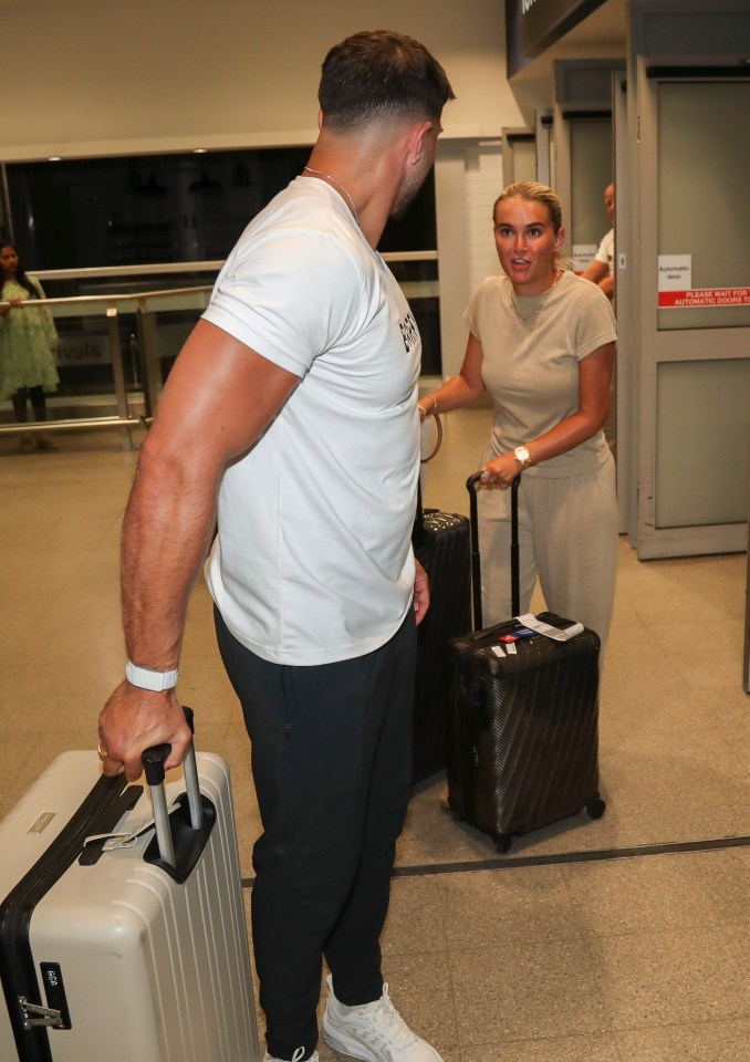 Molly Mae y Tommy Fury llegan a un aeropuerto con equipaje.
