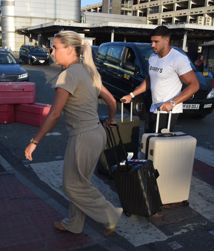 Molly Mae y Tommy Fury llegan a un aeropuerto con equipaje.