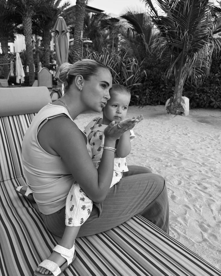 Foto en blanco y negro de una mujer y un niño pequeño soplando besos.