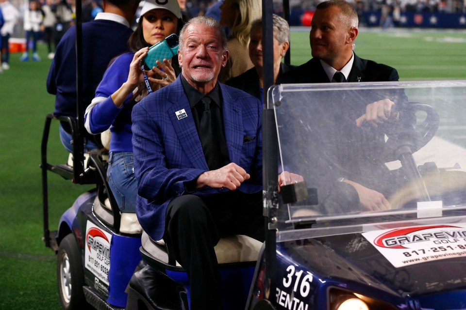 Jim Irsay, propietario de los Indianapolis Colts, montando en un carrito de golf antes de un juego de la NFL.