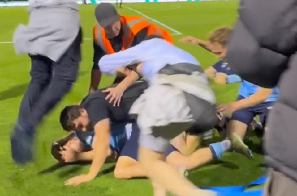 Captura de pantalla de una acumulación de personas en un campo de fútbol.