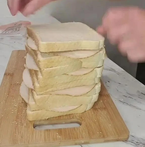 Una pila de sándwiches en un tablero de corte.