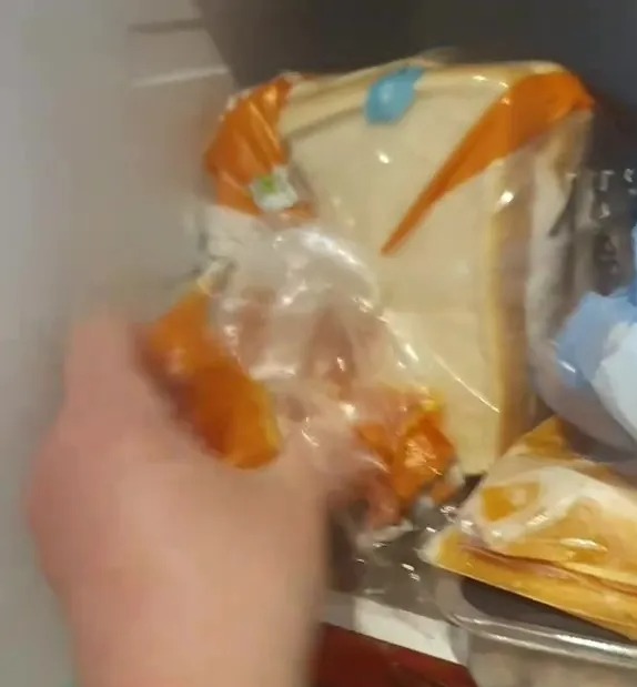 Alcance la mano en un refrigerador lleno de varios alimentos.