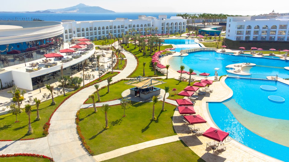 Vista aérea de Rixos Radamis Resort con piscinas y palmeras.