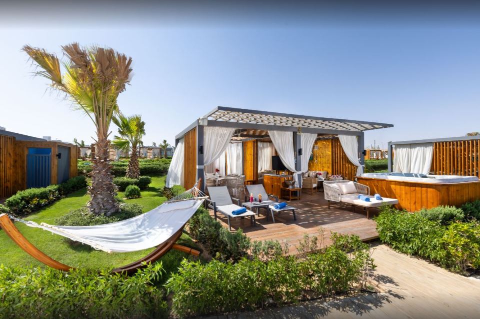 Rixos Radamis Resort Cabana con bañera de hidromasaje y hamaca.
