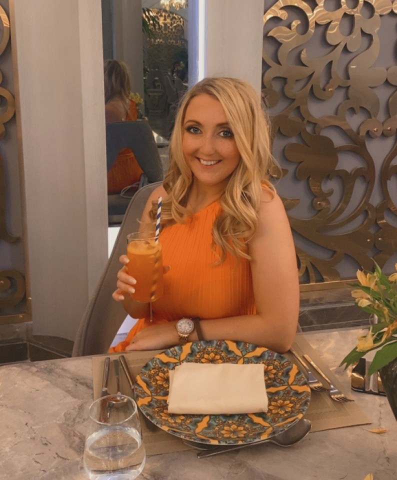Mujer con vestido de naranja en Rixos Radamis, sosteniendo una bebida.