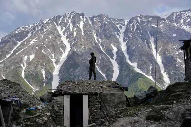 Un soldado del ejército indio mantiene una vigilia de uno de los puestos de avance a lo largo de la línea de control entre India y Pakistán durante una gira de medios en algún lugar del norte de Cachemira controlada por la India, el lunes 19 de mayo de 2025. (AP Photo/Mukhtar Khan)