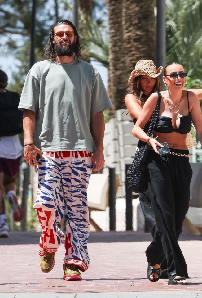 Andy Carroll y Lou Teasdale caminan juntos en Ibiza.
