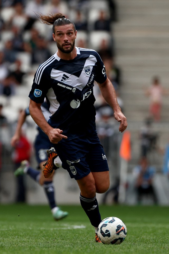 Andy Carroll, un jugador de fútbol, corriendo con el balón.