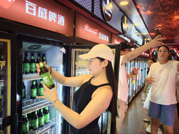 Una mujer mira una botella de cerveza