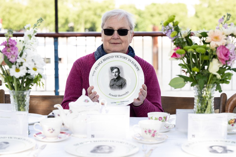 Mujer sosteniendo el plato conmemorativo del héroe de la Segunda Guerra Mundial Arnold Sharrocks.