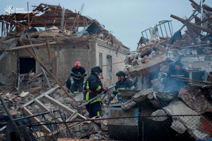 Bomberos que buscan a través de los escombros