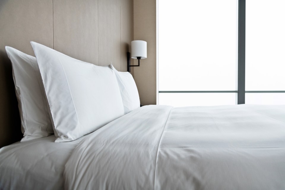 Cama hecho en una moderna habitación de hotel.
