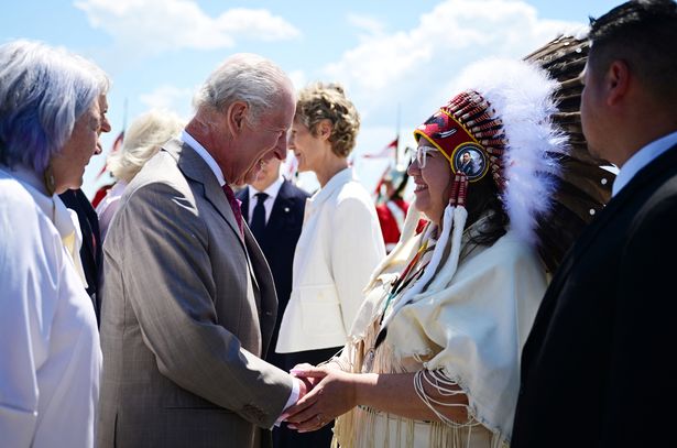 El rey Carlos III reacciona cuando es recibido por un anciano después de llegar al aeropuerto internacional de MacDonald-Cartier en Ottawa