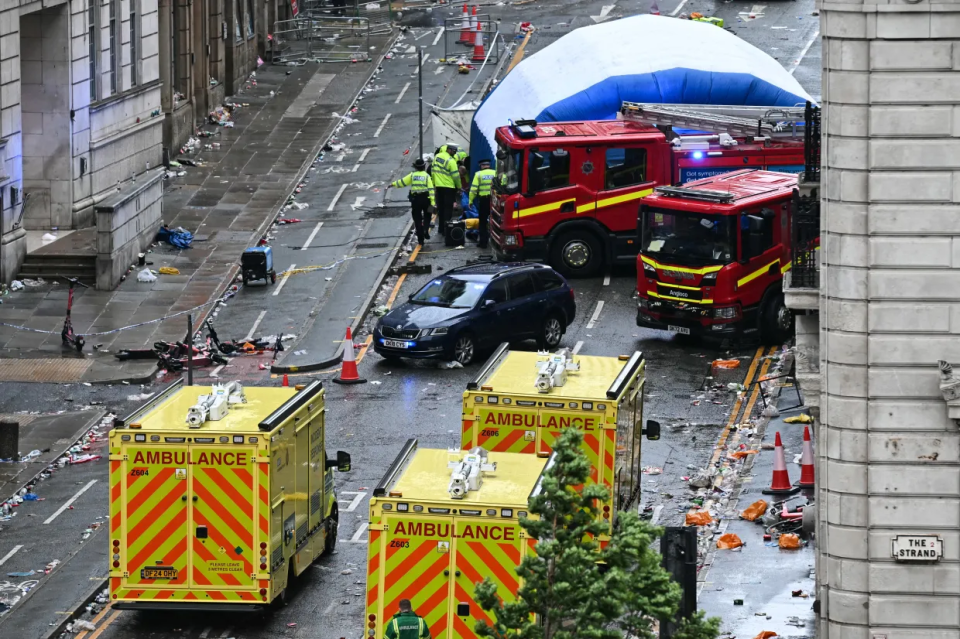 Vehículos de emergencia y escombros en una calle de la ciudad.