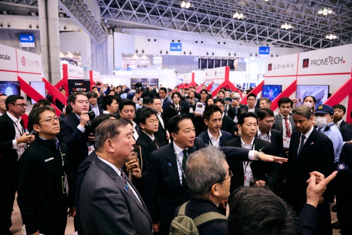 Un gran grupo de personas se reúnen en la exposición DSEI Japan 2025