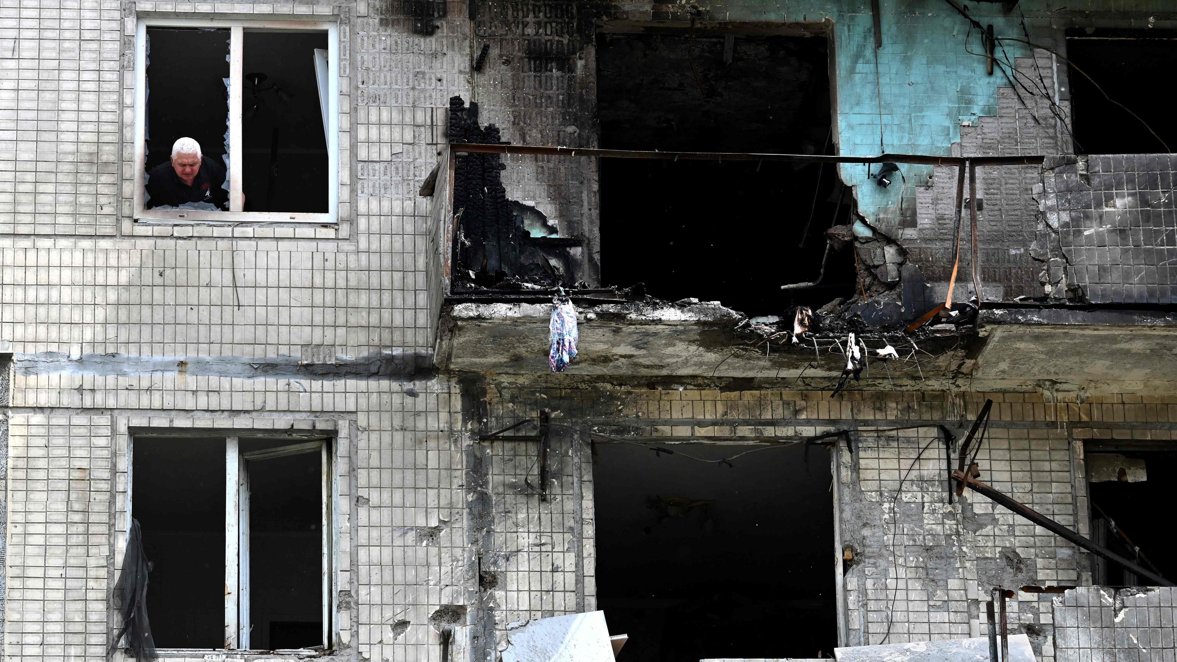 Kiev: Un residente mira por la ventana de una casa que fue golpeado por un dron ruso el 24 de mayo de 2025.