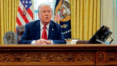 El presidente Donald Trump sentado en el escritorio resuelto