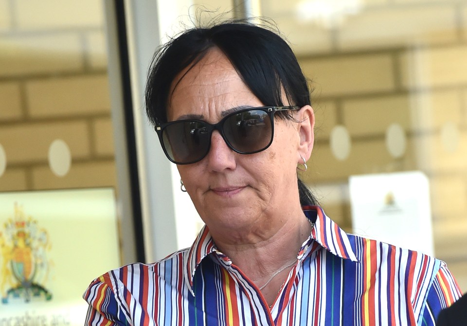 Foto de cabeza y hombros de una mujer con gafas de sol y una camisa a rayas.