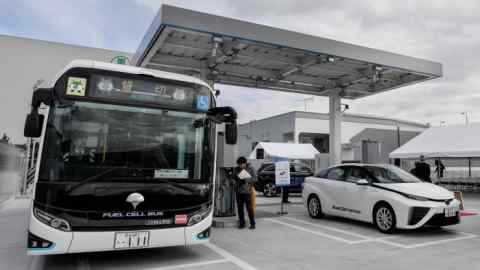 Un autobús de pila de combustible de Toyota y un vehículo de celda de combustible Honda Clarity en una estación de hidrógeno en Tokio