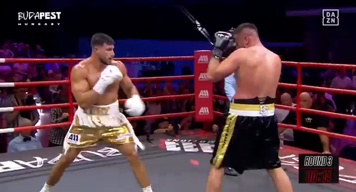 Dos boxeadores frente a los demás en un anillo de boxeo.