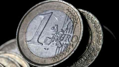 Una moneda de un euro se encuentra encima de una moneda de una libra en esta fotografía arreglada en Londres