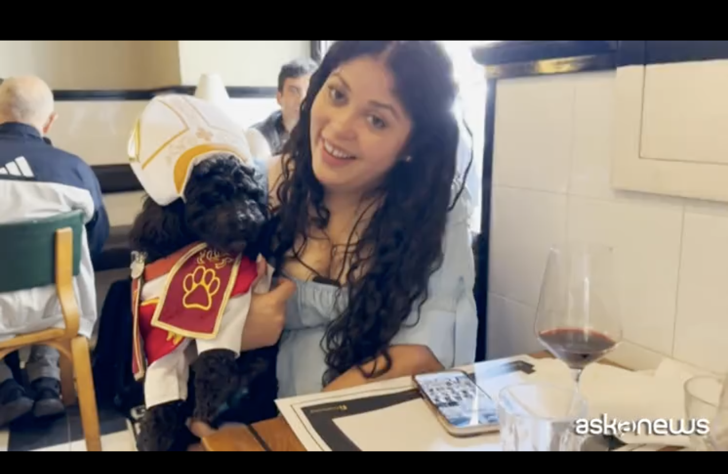 Vestido con un disfraz del Papa, Romeo, un caniche negro,