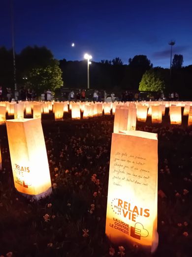 Velas encendidas en el evento, simbolizando la lucha contra el cáncer.