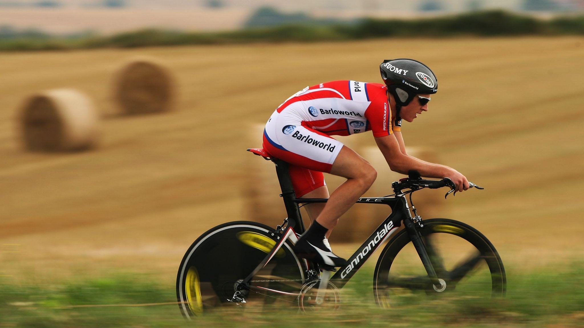 Geraint Thomas in Barloworld kit rides his time trial bike past a field of hay bales at the 2007 Tour de France